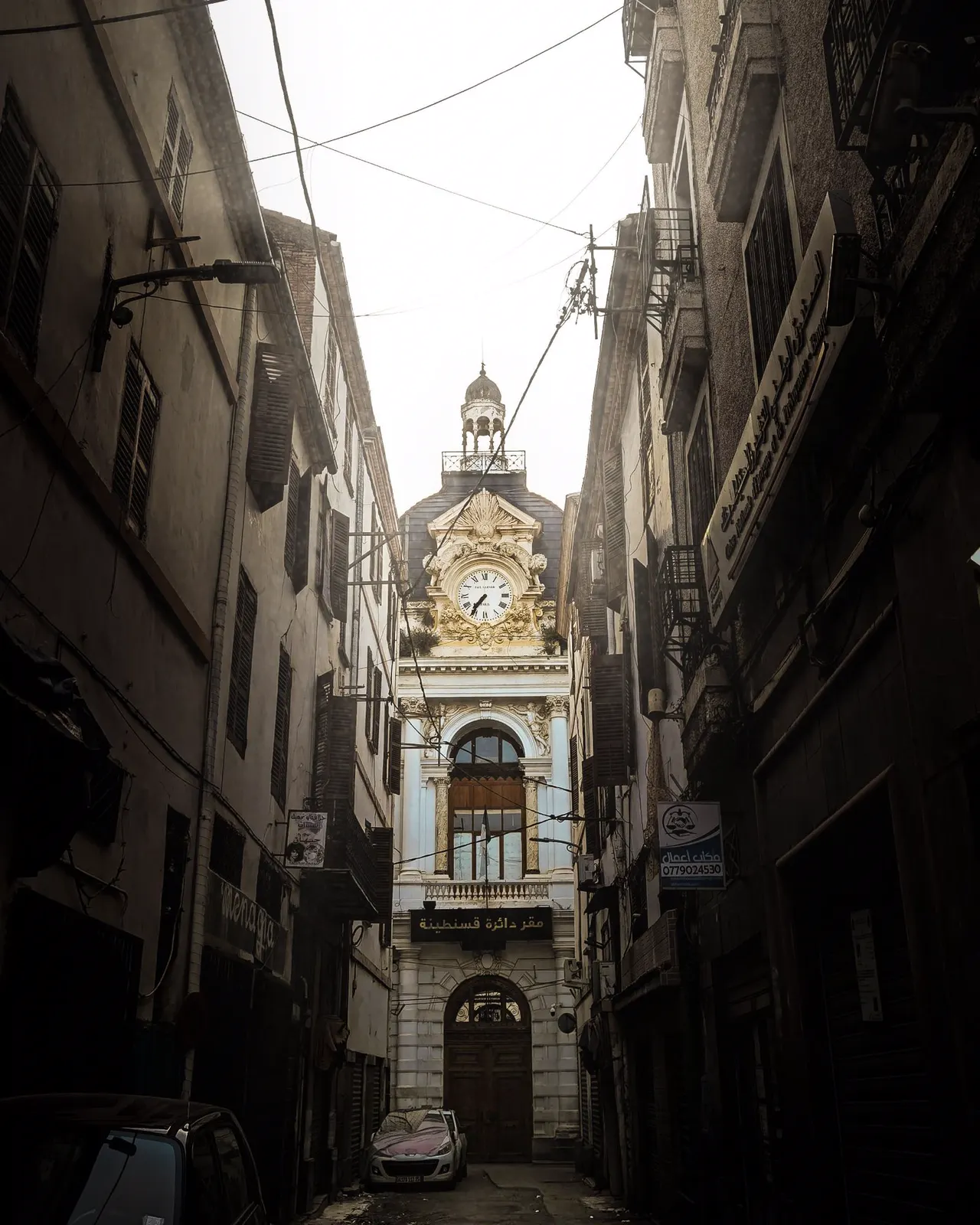 Narrow street of the old town leading to a clock tower